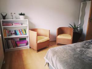 a bedroom with two chairs and a book shelf at Tolles seenahes Apartment am Bodensee mit großer Terrasse in Sipplingen