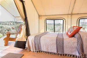 een bed achterin een bus met ramen bij BaseCamp 37° in Kanab