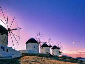 a group of windmills sitting on top of a hill at Town Apartment in Mikonos