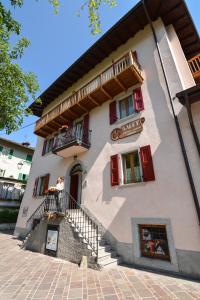 a large white building with stairs and windows at Bed and Breakfast Galet in Ledro