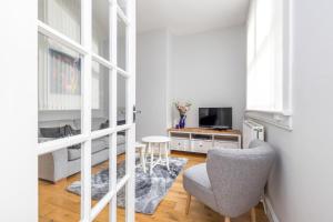 a living room with a chair and a television at Cosy town centre cottage in Peebles