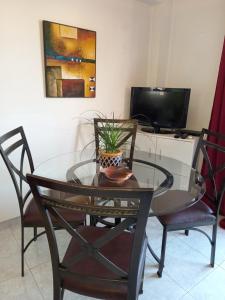 a glass table with chairs and a tv in a room at Old Town apartment 2 in Larnaca