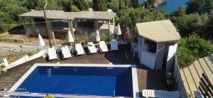 a house with a swimming pool next to a building at spyridoula studio in Paleokastritsa