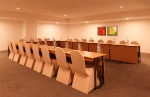 una gran sala de conferencias con una mesa larga y sillas en Lemon Tree Hotel, Dehradun, en Dehradun