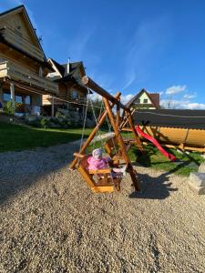 a swing with a doll on it in a yard at Domki Góralskie Dwa Misie in Bukowina Tatrzańska