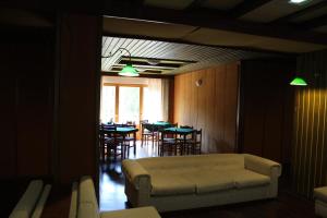 a dining room with tables and chairs and a couch at casa Luca Prato Verde 1 in Pescasseroli