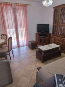 een woonkamer met een bank en een tv bij Apartman S Igalo in Herceg-Novi