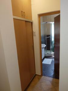 een badkamer met een houten deur en een bad bij Apartman S Igalo in Herceg-Novi