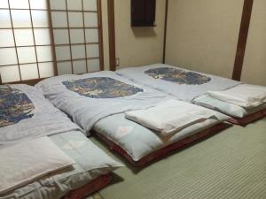 a group of twin beds sitting next to each other at Nihonkan in Kyoto