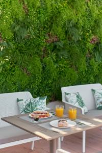 7Rizes Luxury Living في مدينة هيراكيلون: طاولة مع طبقين من الطعام وكأسين من عصير البرتقال