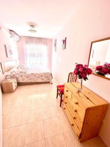 トレビエハにあるTorrevieja comfortable apartmentのベッドルーム1室(ベッド1台、花のテーブル付)