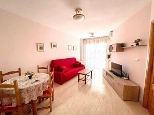 トレビエハにあるTorrevieja comfortable apartmentのリビングルーム(赤いソファ、テーブル付)