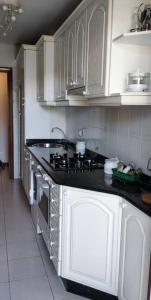 a kitchen with white cabinets and a black counter top at Acogedor apartamento en la playa de Trengandín también para tu mascota in Noja