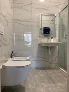 uma casa de banho com um WC, um lavatório e um chuveiro em Lovely 1-bedroom Condo in Tirana WiFi-Netflix-AC em Tirana