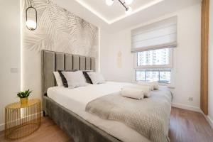Un dormitorio con una cama grande y una ventana en Apartment 32 by the seaside Gdańsk Letnica, en Gdansk