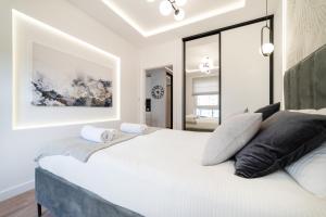 1 dormitorio con 1 cama blanca grande con almohadas negras en Apartment 32 by the seaside Gdańsk Letnica, en Gdansk