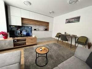 een woonkamer met een bank, een tv en een tafel bij CityApartment in Sofia