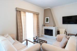 a living room with white furniture and a fireplace at Sunset House Near Athens Airport in Spata