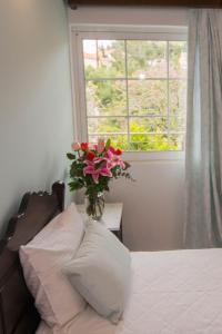 a bedroom with a bed with a vase of flowers on a window at Afrodite Hotel Apartments in Myrina