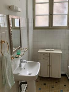 a white bathroom with a sink and a mirror at Treignac Tourelles in Treignac