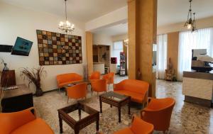 een lobby met oranje stoelen en een wachtkamer bij Hotel Corona in Rimini