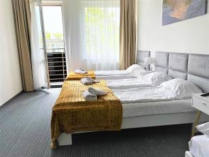 1 dormitorio con 2 camas y una mesa con toallas en Apartamenty Planeta Mielno, en Mielno