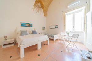 a bedroom with a bed and a table and chairs at B&B Gallipoli Vecchia in Gallipoli