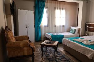 a hotel room with two beds and a chair at Grand Erken Hotel in Antalya