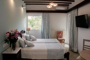 a bedroom with a large bed and a window at Afrodite Hotel Apartments in Myrina