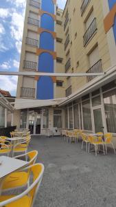een groep stoelen en tafels voor een gebouw bij Hotel Corona in Rimini