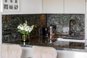 a kitchen with a counter with a vase of flowers at Apartment im Olympia Hotel Schilksee in Kiel