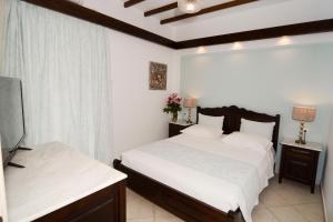 a bedroom with two beds and a flat screen tv at Afrodite Hotel Apartments in Myrina