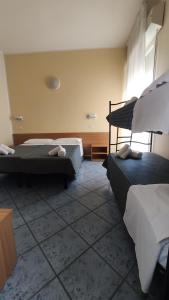 En eller flere senger på et rom på Hotel Corona