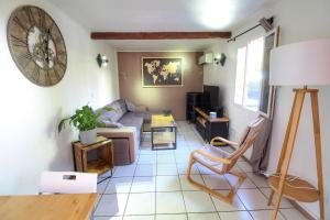 salon z kanapą i stołem w obiekcie Appartement proche toutes commodités w mieście Tulon