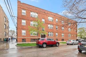 a red van parked in front of a brick building at 2BR Stylish Apartment in Avondale close to Shops - Roscoe 1W in Chicago