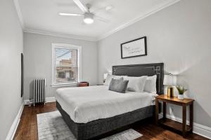 a bedroom with a large bed with a ceiling fan at Stylish 2BR Apt in Vibrant Avondale near Shops - Roscoe 1W in Chicago