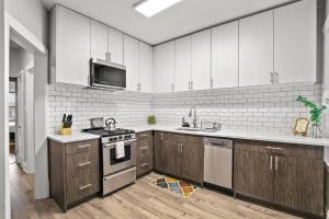 a kitchen with white cabinets and a stove top oven at 2BR Stylish Apartment in Avondale close to Shops - Roscoe 1W in Chicago