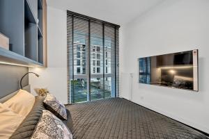 een woonkamer met een bank en een groot raam bij Luxury Copper Apartment in Łódź