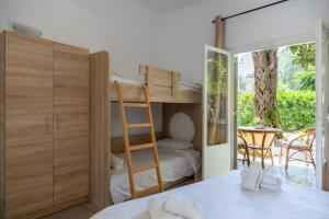a bedroom with a bunk bed with a ladder and a table at Wilde Rose Hotel in Dassia