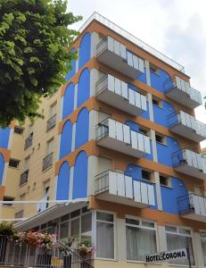 een blauw appartementencomplex met balkons bij Hotel Corona in Rimini