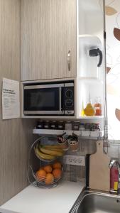 a kitchen with a microwave and a bowl of fruit at Casa Doppia in Zakynthos