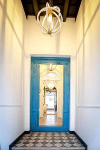 a blue door in a hallway with a chandelier at El Rincón de Silvia. in Ayamonte