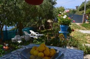 a bowl of lemons on a table in a garden at Mirror Beach Ksamil - Vila Zervo in Sarandë