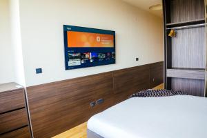 a bedroom with a bed and a tv on the wall at The Apartment - Luxury Stay Budva in Budva