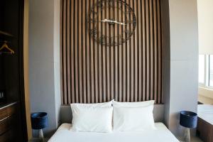 a bedroom with a bed with a large clock on the wall at The Apartment - Luxury Stay Budva in Budva
