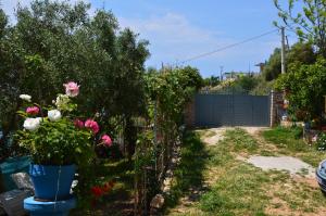 a garden with flowers and a fence at Mirror Beach Ksamil - Vila Zervo in Sarandë