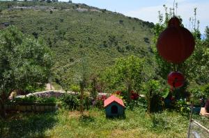 a garden with a bird house and a hill at Mirror Beach Ksamil - Vila Zervo in Sarandë