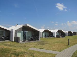 a row of houses with tables and chairs in a field at Apelvikstrand in Varberg