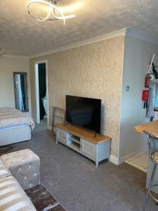 sala de estar con TV de pantalla plana en la pared en The Nest, Livingston, en Livingston