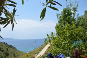 a view of a mountain with the ocean in the background at Mirror Beach Ksamil - Vila Zervo in Sarandë